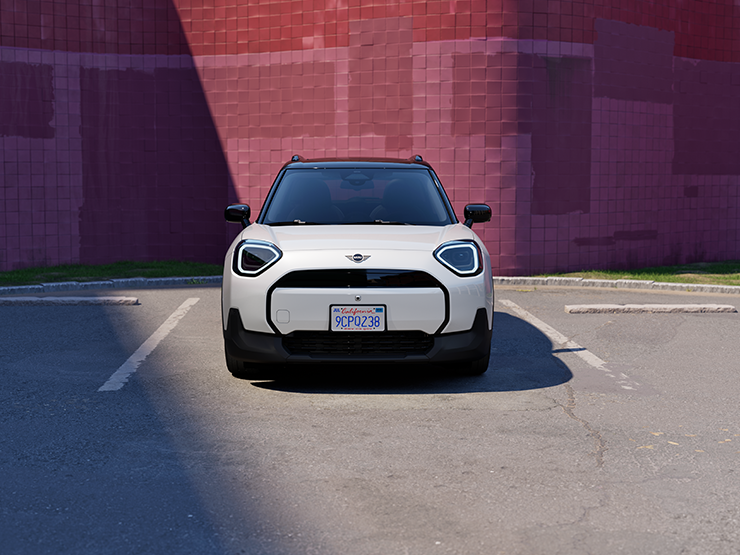 Den helelektriske MINI Aceman i Nanuq White og svart tak, som står parkert, sett forfra.