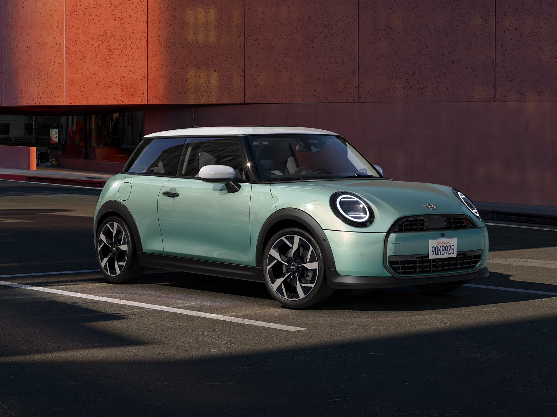 MINI Cooper i Ocean Wave Green med hvitt tak, sett forfra og fra siden.