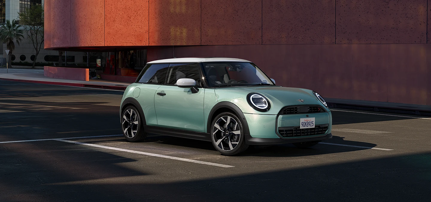 MINI Cooper i Ocean Wave Green med hvitt tak, sett forfra og fra siden.