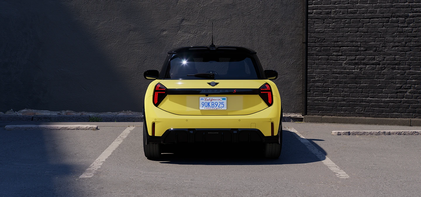 MINI Cooper i Sunnyside Yellow med svart tak som parkerer, sett bakfra.