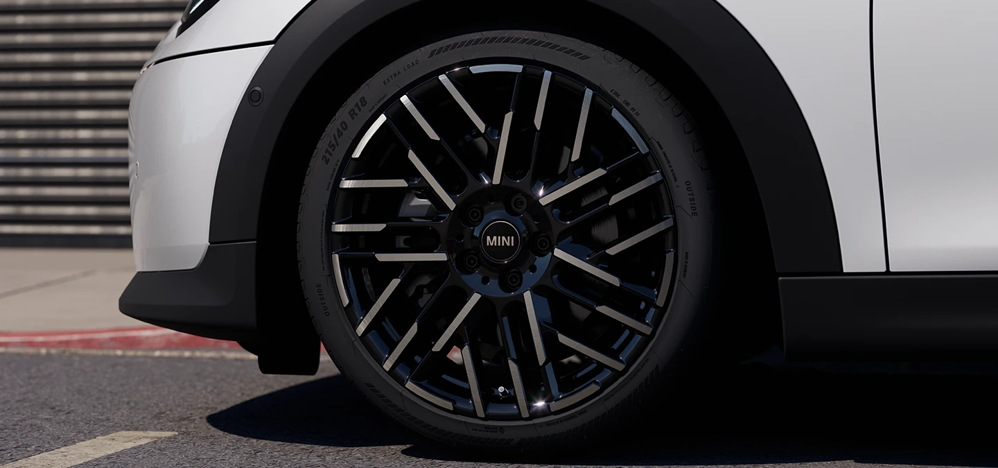 Nærbilde av MINI Cooper 5-dørs i Nanuq White med Night Flash Spoke 2-tonede felger.