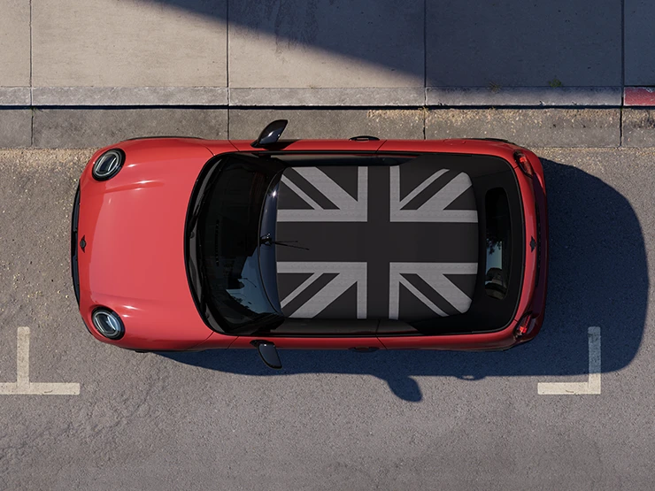 MINI Cooper Cabrio i Chili Red med MINI Yours tak som står i ei gate, sett ovenfra.