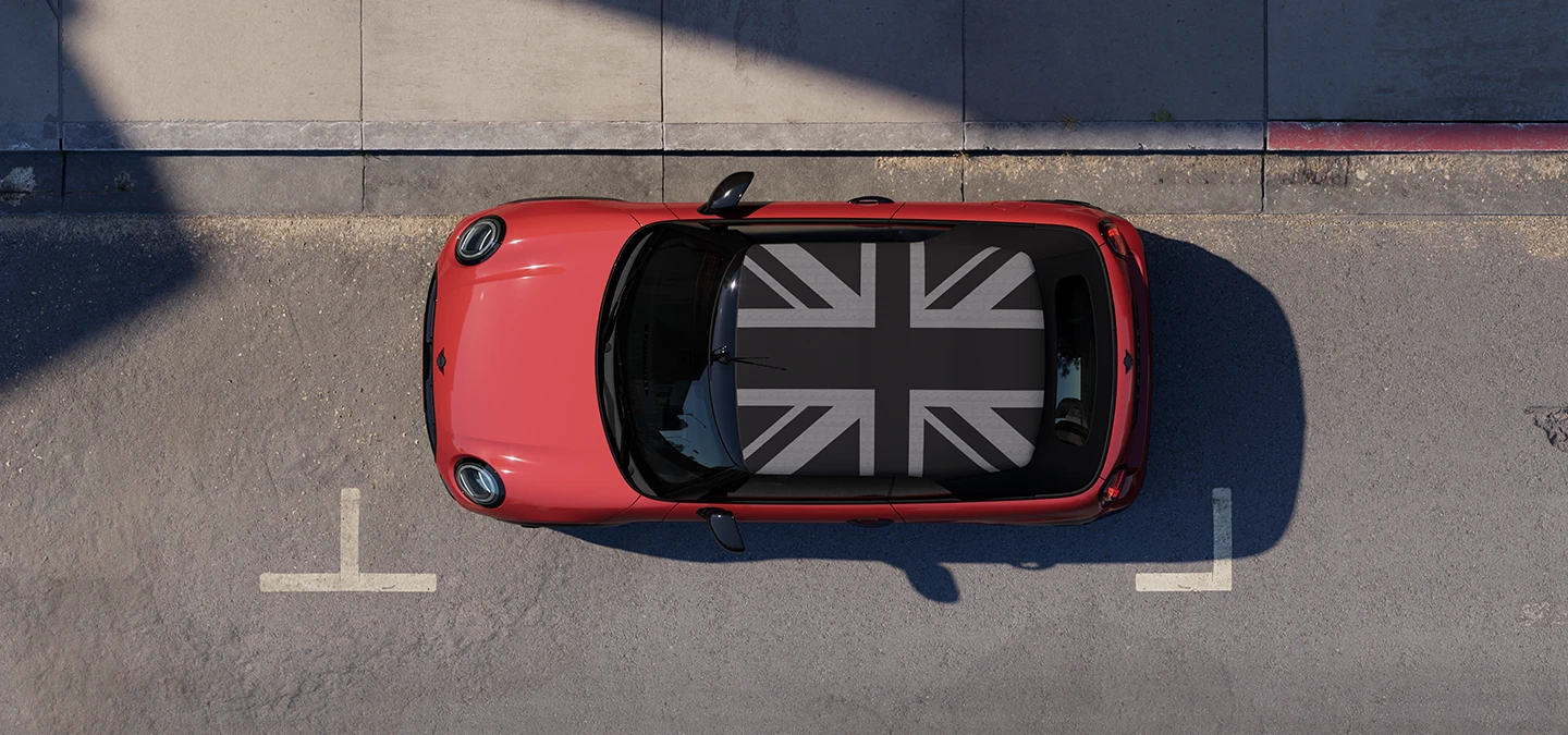 MINI Cooper Cabrio i Chili Red med MINI Yours tak som står i ei gate, sett ovenfra.