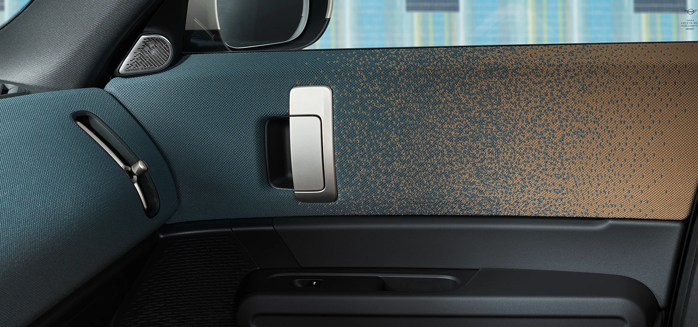 Nærbilde av interiørdesignet til den helelektriske MINI Countryman med fokus på døren og dashbordet.