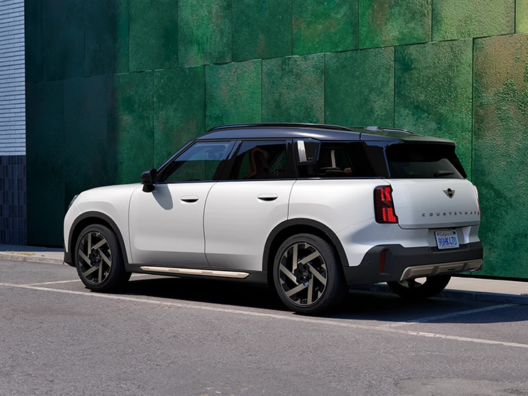 MINI Countryman i Nanuq White med svart tak som står i ei gate, sett fra siden.