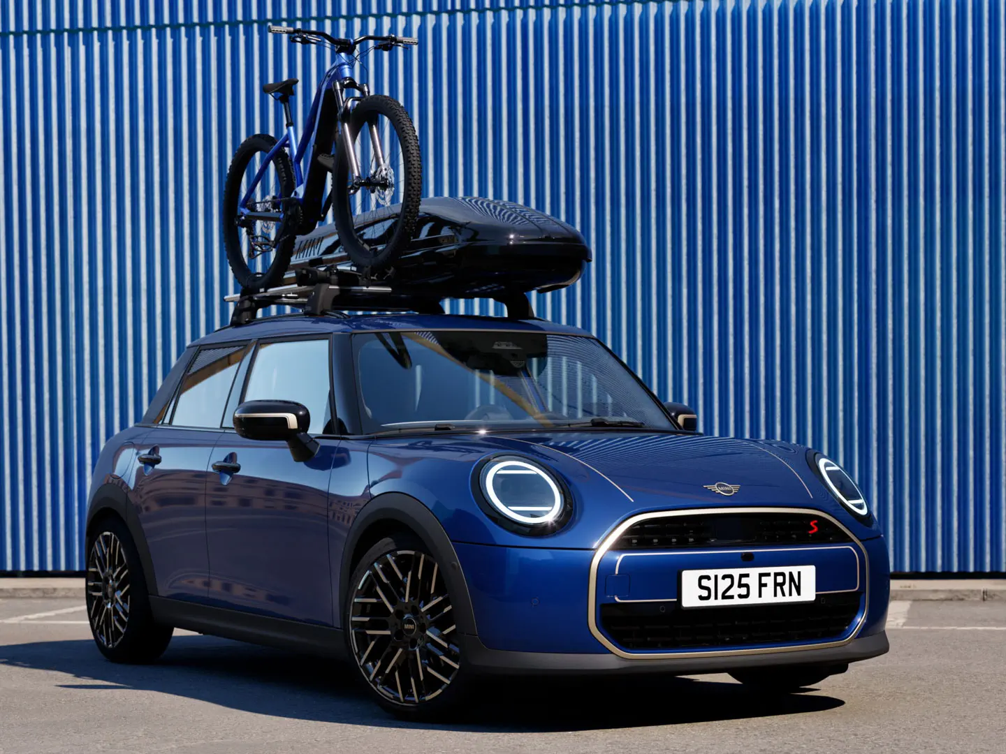 MINI Aceman i Indigo Sunset blå med MINI taksykkelstativ med terrengsykkel og MINI takboks 320 sett forfra.