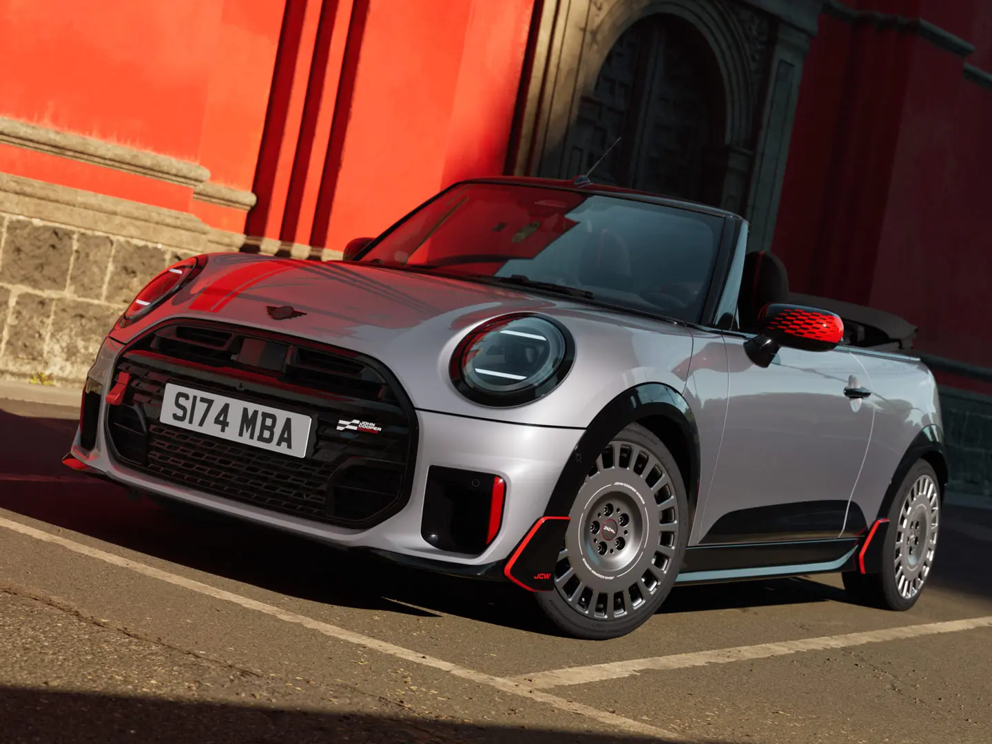 Sølvfarget MINI kabriolet med sportslige JCW-stylingprodukter, innbefattet MINI JCW-speildeksler, sportsstriper og vinge.