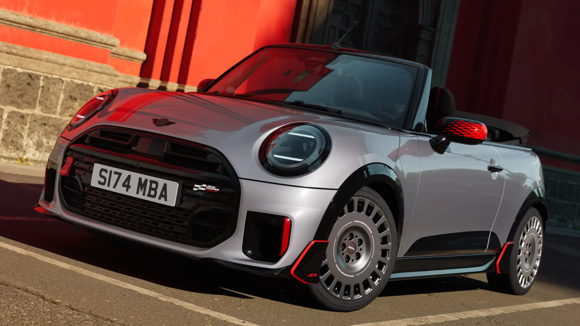 Sølvfarget MINI kabriolet med sportslige JCW-stylingprodukter, innbefattet MINI JCW-speildeksler, sportsstriper og vinge.