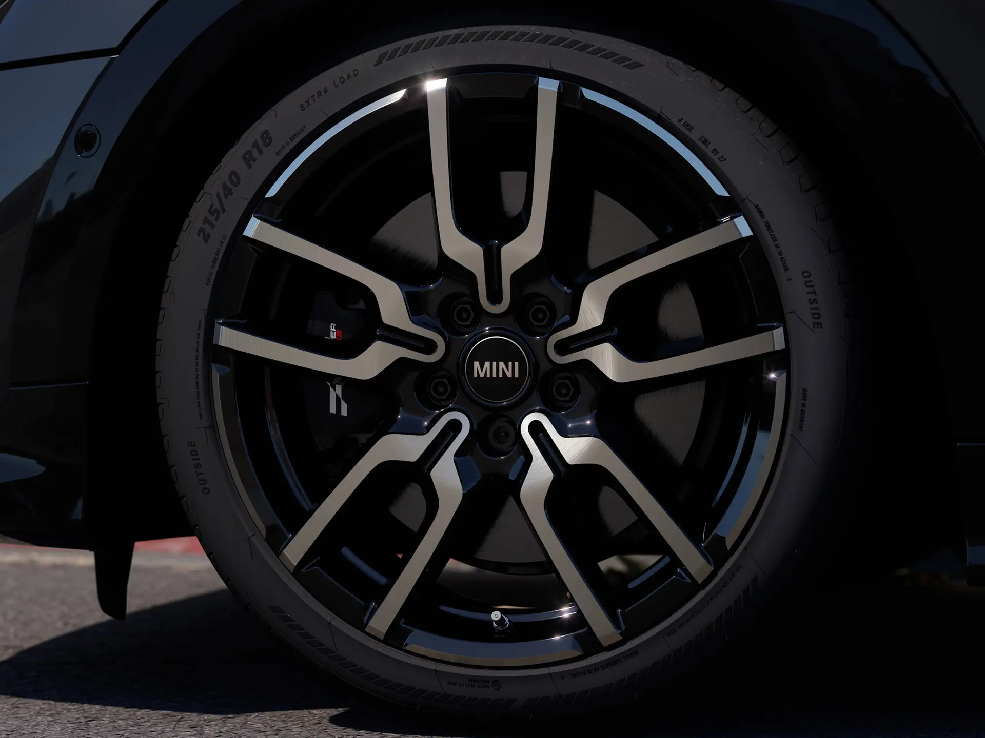 Nærbilde av JCW Lap eiker lettmetallfelg som viser sin særegne åpne eikedesignstruktur i Jet Black-finish.