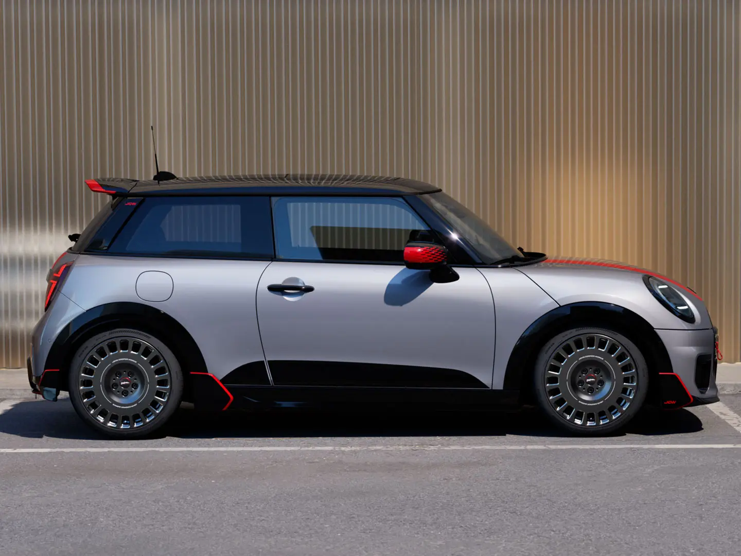 3-dørs MINI Cooper i Melting Silver med John Cooper Works takspoiler for bedre aerodynamikk – sett fra siden.