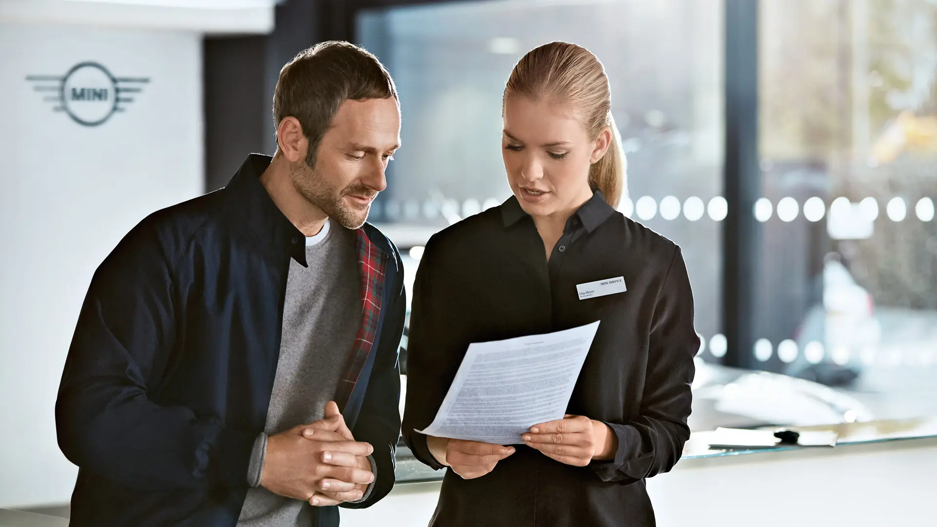 MINI servicerådgiver informerer kunden om serviceplaner ved et MINI senter.