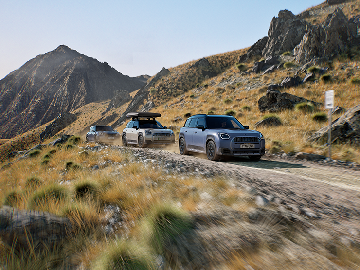 Bilde av flere MINI Countryman Untamed Edition-modeller som utføres i bakkekjøring på en fjellvei.