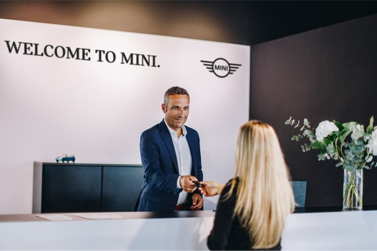 Velkomstområde hos en MINI Partner, med ansatt og kunde